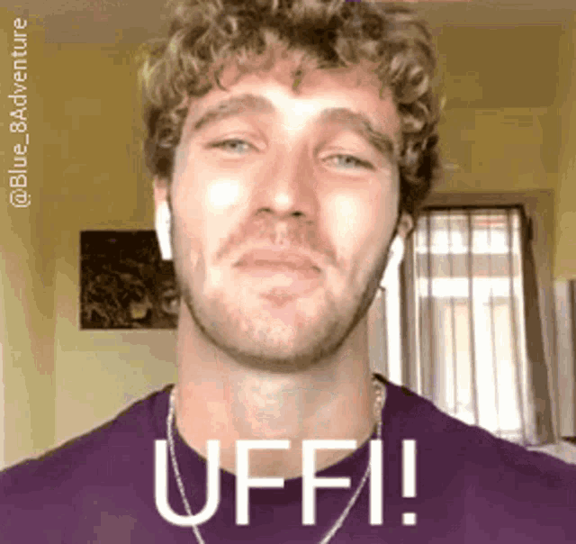 a man with curly hair and a beard is wearing a purple shirt with the word uffi on it
