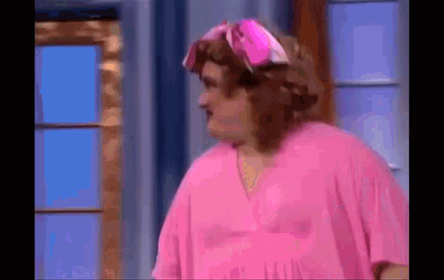 a woman is wearing a pink shirt and a pink headband .