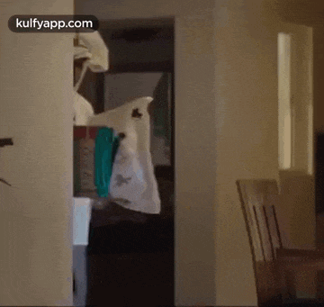 a person is standing in a room with a bag hanging from a hook .