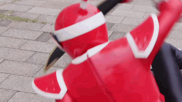 a close up of a person in a red costume on a sidewalk .