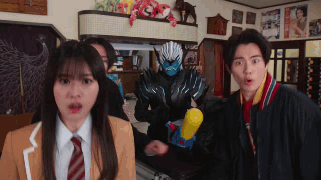 a group of people are standing in a room and one of them is holding a yellow water gun