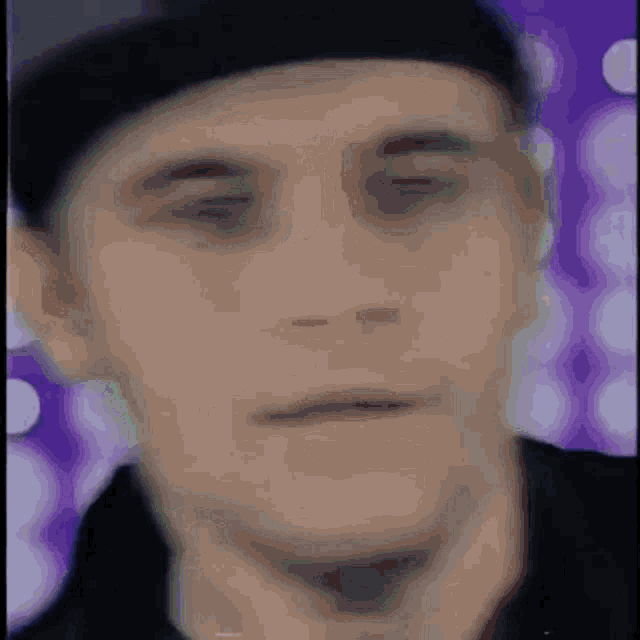 a blurry picture of a man 's face with a hat on