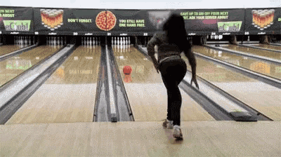 a woman is playing bowling in a bowling alley