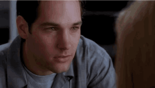 a close up of a man 's face with a woman behind him