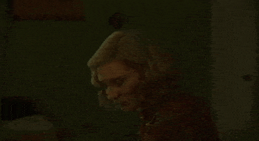 two women are kissing in a dark room in a bedroom .