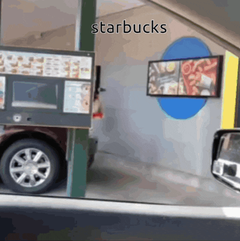 a drive thru at starbucks with a car parked in front of it