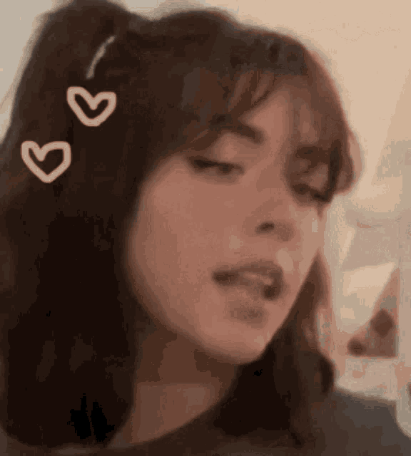 a girl with three pink hearts in her hair looks at the camera