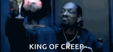 snoop dogg is wearing a blue fur coat and holding a microphone while singing into it .