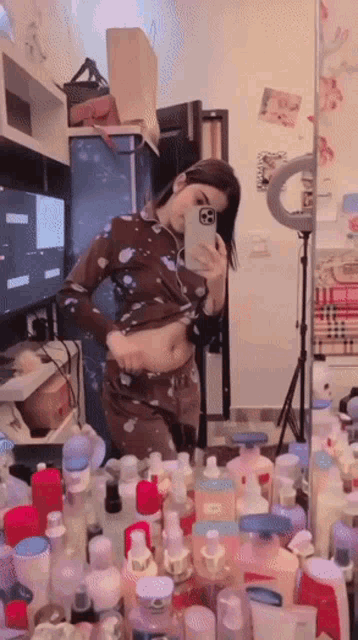 a woman is taking a selfie in front of a mirror surrounded by bottles of lotion