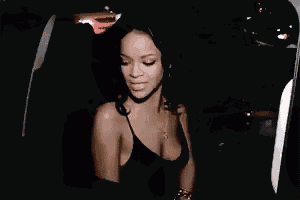 a woman in a black tank top is sitting in the back of a car .