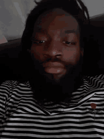 a man wearing a black and white striped shirt with a red rose on it