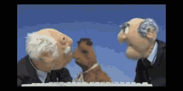 two old men and a stuffed animal are standing next to a keyboard