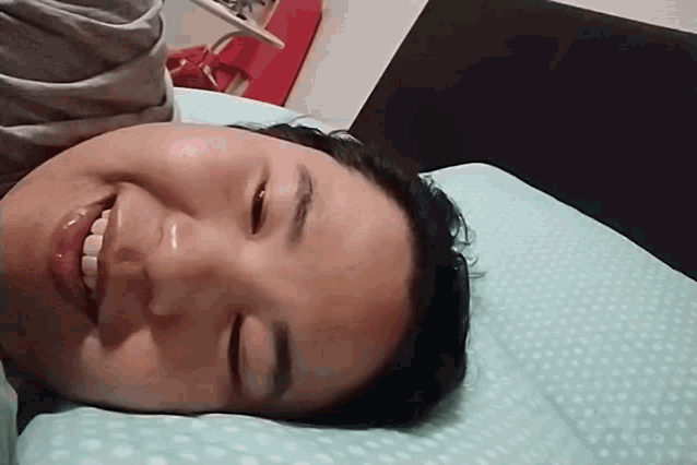 a woman laying on a bed with her eyes closed