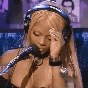 a woman wearing headphones and a bracelet is sitting in front of a microphone .