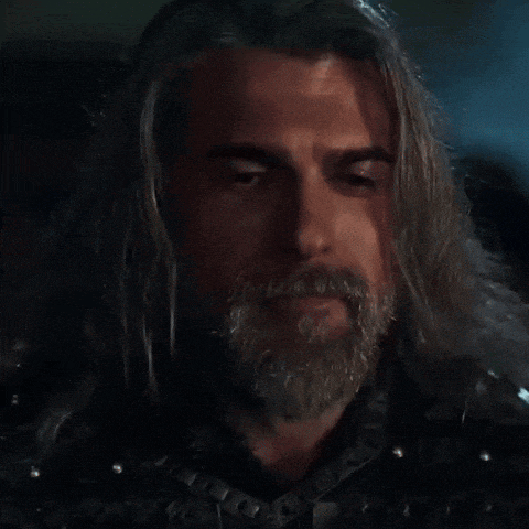a man with long hair and a beard is wearing armor