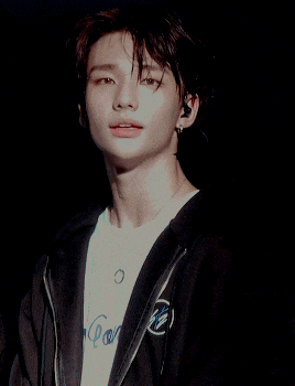 a young man wearing a black jacket and a white t-shirt that says ' coca cola ' on it