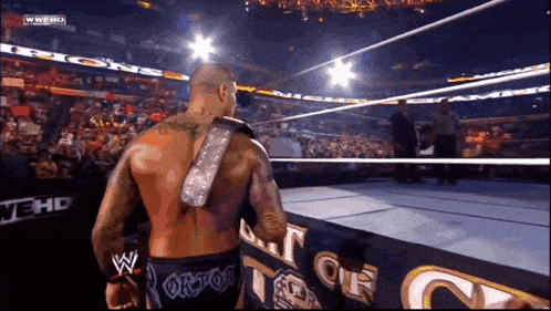 a wrestler with the word orion on his shorts walks out of the ring