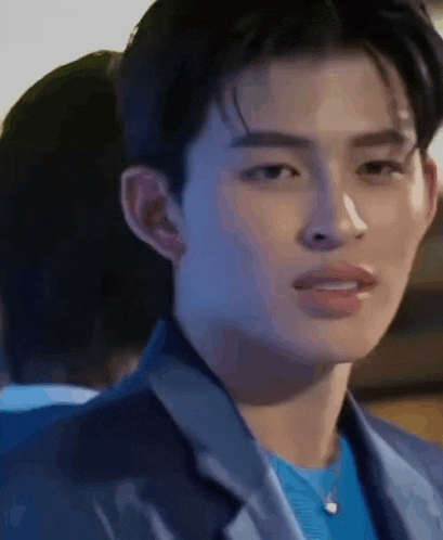 a close up of a young man wearing a blue suit and a blue shirt .