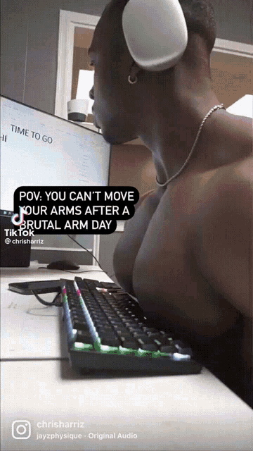 a shirtless man wearing headphones is sitting in front of a computer