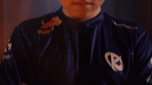 a close up of a person wearing a blue shirt with red bull on it