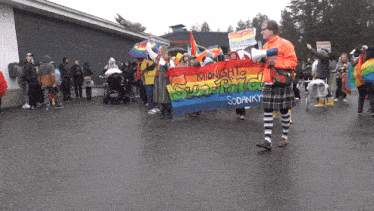 a man in a kilt is holding a sign that says midnight surprise