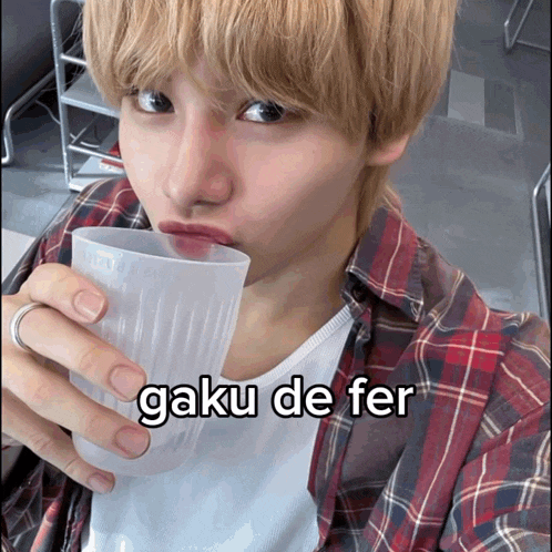 a man in a plaid shirt drinks from a plastic cup with the caption gaku de fer