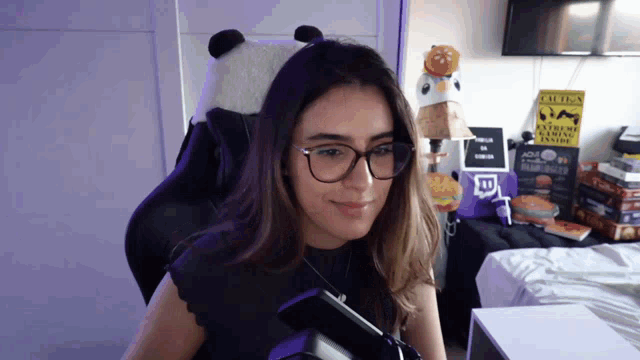 a woman wearing glasses is sitting in front of a sign that says " critics "
