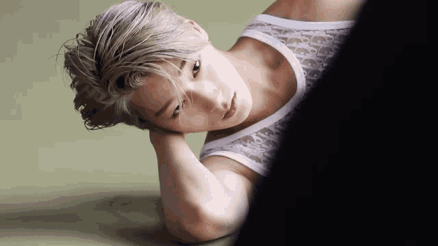 a man wearing a white tank top with dior written on it