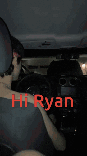 a man is driving a car with the words hi ryan written on the dashboard