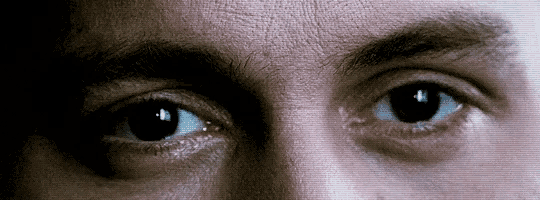 a close up of a man 's eyes with a few white spots