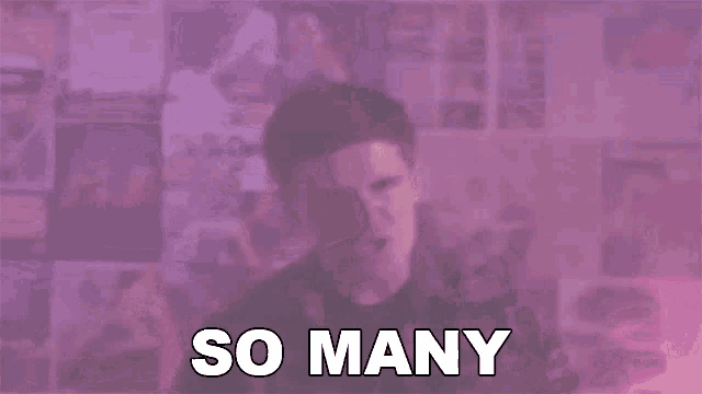 a man is standing in front of a pink wall with the words `` so many '' written above him .