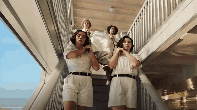 a group of women are walking up a set of stairs with the words death in the nile written on the bottom