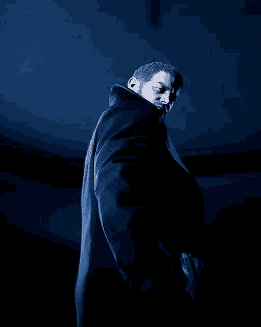 a man holding a gun in a dark room