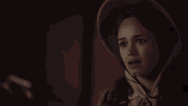 a woman wearing a straw hat with a ribbon around her head