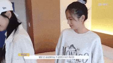 two girls are standing next to each other and one of them is wearing a shirt that says monaco on it