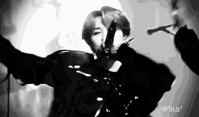 a black and white photo of a person holding a microphone in their hand .