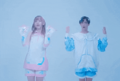 a boy and a girl are standing next to each other in a room .