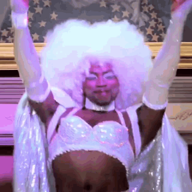 a man in a white wig and gloves is dancing
