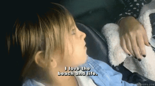 a little girl says " i love the beach and life " while laying down