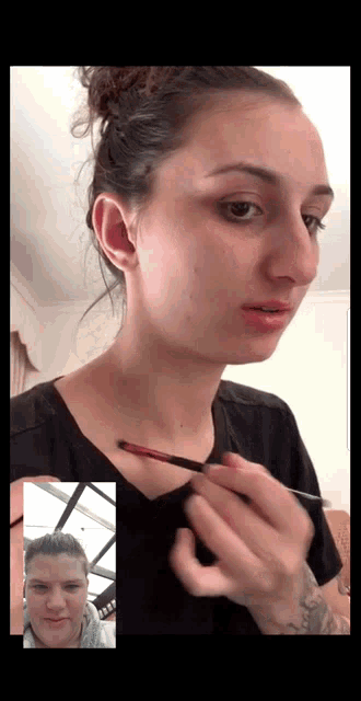 a woman applying makeup to another woman 's face on a video call