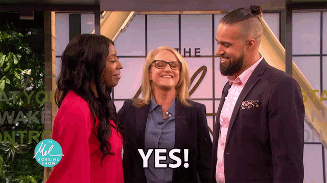 two women and a man are standing in front of a sign that says " the mel robbins show "
