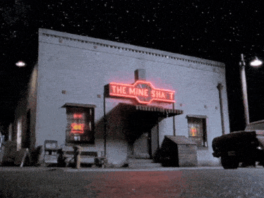 a building with a neon sign that says " the mine shaft "