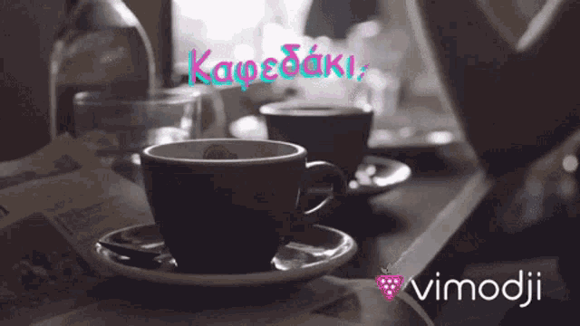 a cup of coffee sits on a saucer on a table next to a newspaper and a bottle of water