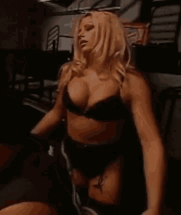 a woman in lingerie is standing in a dark room .