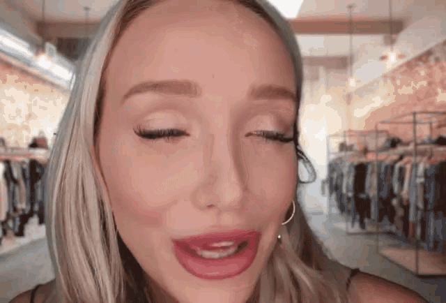 a woman with her eyes closed looks at the camera