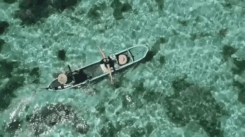 an aerial view of a boat floating on top of a turquoise ocean .