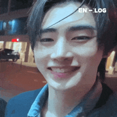 a close up of a young man 's face with a smile on his face