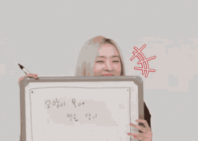 a woman is holding a whiteboard with chinese writing on it
