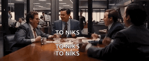 a group of men are sitting around a table with the words to niks to niks on the bottom