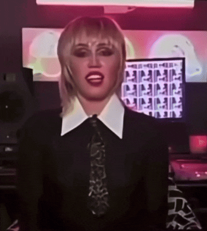 a woman wearing a black shirt and tie is standing in front of a computer screen .